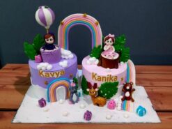Colorful Rainbow Fantasy Twin Birthday Cake with girl figurines, animals, and gifts from Lallantop Cake Shop